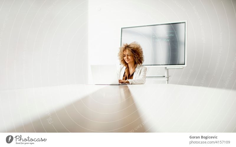 African American businesswoman sitting and working on laptop in the modern office adult african afro american beautiful black confident corporate curly employee