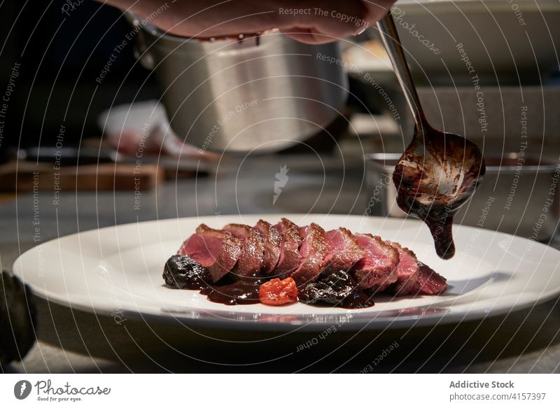 Crop cook preparing beef in chocolate sauce restaurant chef garnish exquisite palatable meat delicious kitchen culinary professional dish meal food gourmet