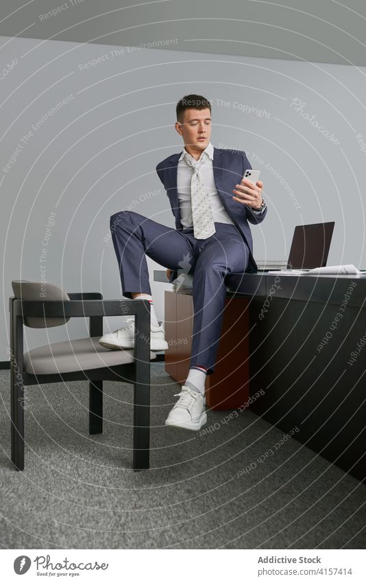 Stylish businessman on cellphone in office smartphone sit table using entrepreneur style male workplace chair occupation device gadget busy job professional