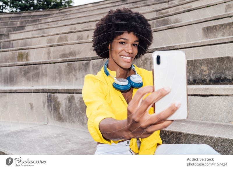Cheerful black woman taking selfie in city self portrait afro hairstyle smartphone using charming smile female ethnic african american cheerful mobile young