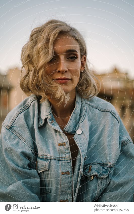 Content woman in city in evening tranquil denim jacket relax carefree twilight appearance female calm rest dusk enjoy pleasure freedom summer outfit serene