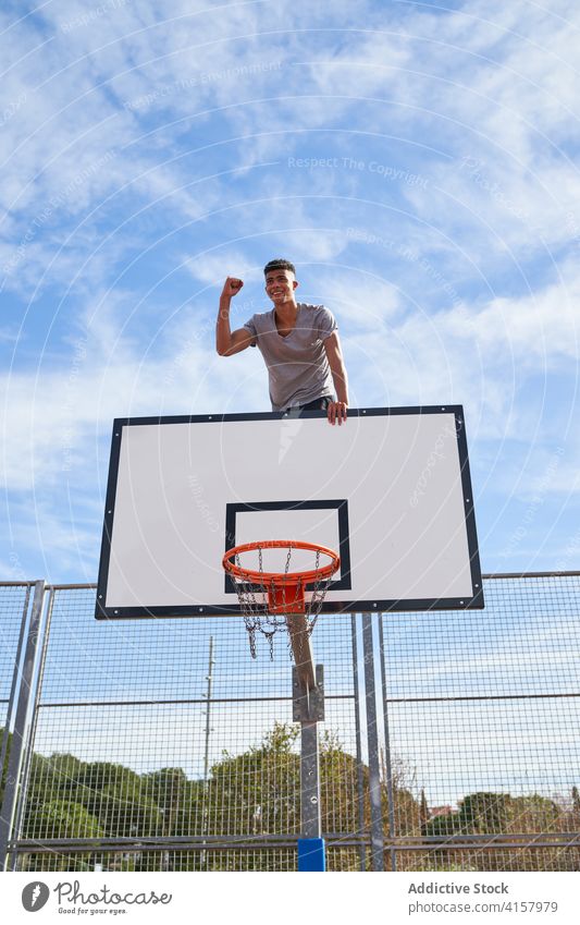 Young man resting on basketball court hoop training sport game young athlete backboard sports ground sportsman workout ethnic male streetball wellness dream