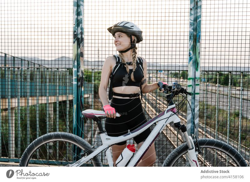 Female cyclist standing near grate fence woman road bicyclist glove concept bridge protect female freedom activity route barrier journey adventure travel path