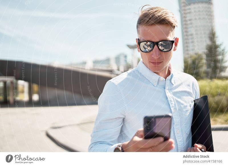 Modern man in stylish sunglasses on phone in city style smartphone urban modern confident trendy young male mobile communicate connection lifestyle device