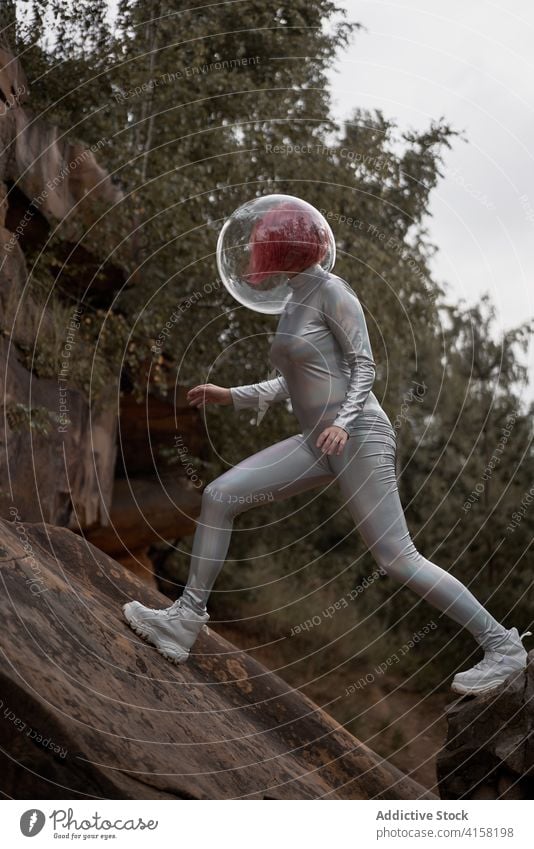 Smiling futuristic woman in sliver suit space astronaut positive young rock stone cosmonaut costume concept female silver helmet smile confident happy cheerful