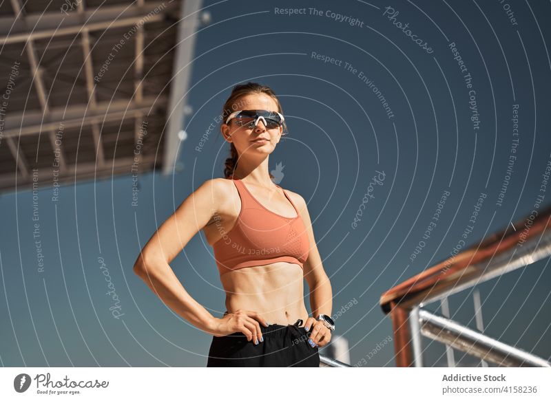 Young woman in sportswear and sunglasses standing at stadium sporty eyewear fit active confident trendy style fashion young female modern slim lifestyle fitness