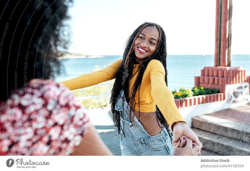 Carefree black women holing hands at seafront best friend holding hands delight summer together promenade friendship carefree freedom ethnic african american