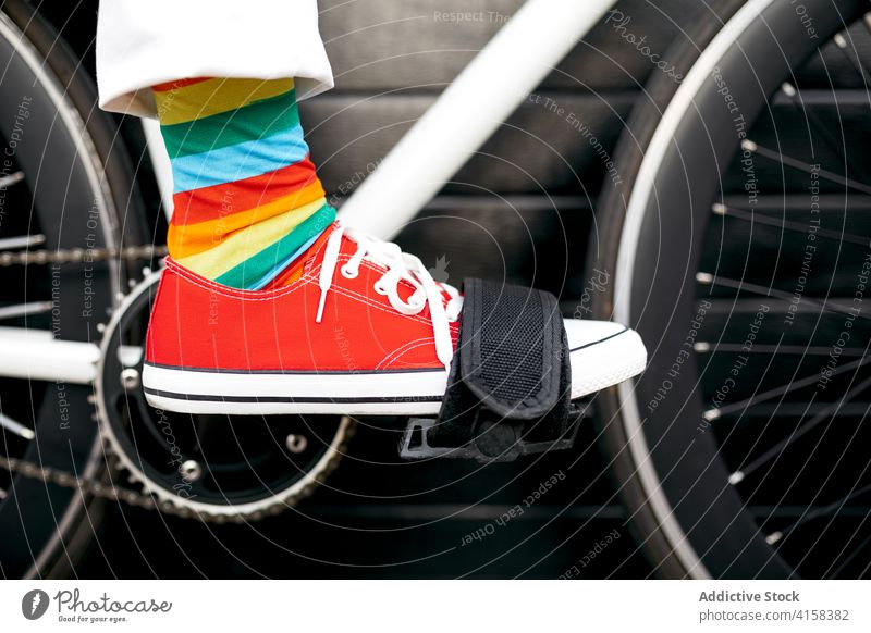 Crop person in colorful socks on bicycle stripe rainbow creative fun bike vehicle modern city street urban style trendy transport town hipster outfit cool