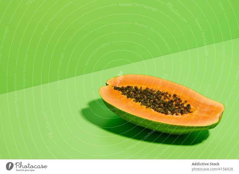 Half of ripe papaya on green background fruit half cut piece fresh tropical exotic color colorful bright vivid vibrant seed sweet organic delicious halved
