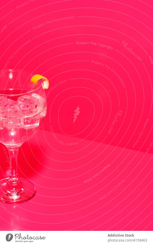 Glass of gin tonic in composition with lemon on table in pink background glass alcohol taste drink citrus beverage citron fruit fresh fluid cool refreshment