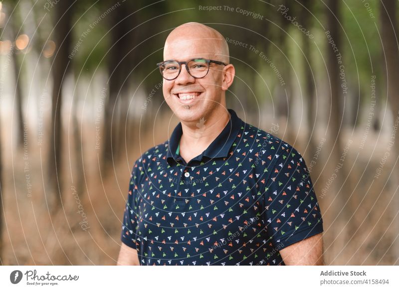 Delighted man in urban park bald handsome alley portrait delight relax weekend smile eyeglasses male enjoy content happy cheerful style satisfied pleasant