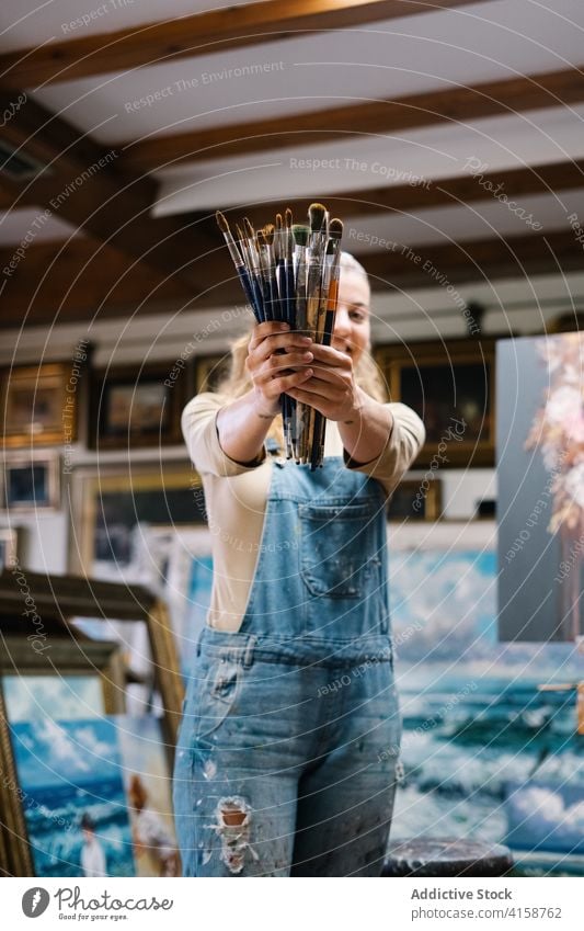 Happy female artist with paintbrushes woman creative workshop talent tool draw hobby craft inspiration artwork occupation skill professional create imagination