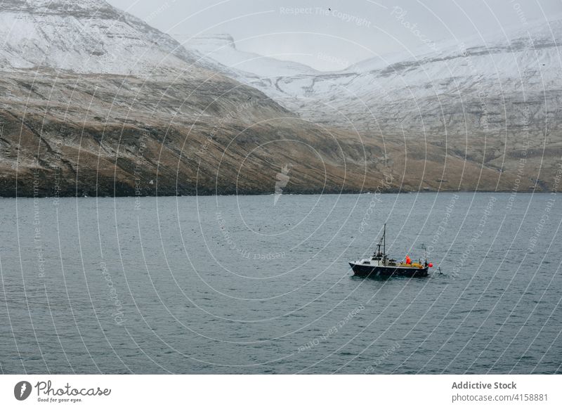 Fish boat on the sea near snowy mountain fishing boat tourism scenery ferry sky nature water blue travel mountains cold landscape ocean winter icelandic