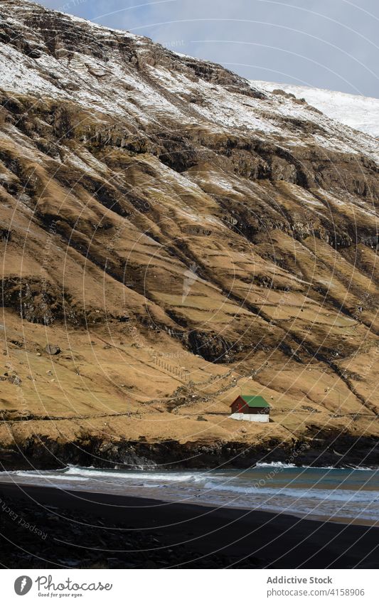 Small cabin wooden house in mountains on Faroe Islands village settlement winter snow river season cold residential faroe islands scenery breathtaking scenic
