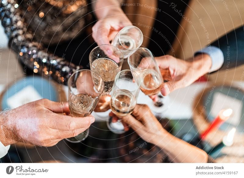 Company of people celebrating Christmas together christmas party home celebrate clink glass company cheers champagne beverage toast gather event occasion group