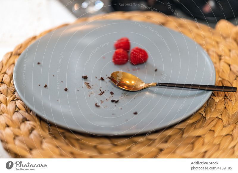 Empty plate with berries on table empty dirty dessert spoon party crumb yummy celebrate food berry raspberry festive ceramic stain smear object messy utensil
