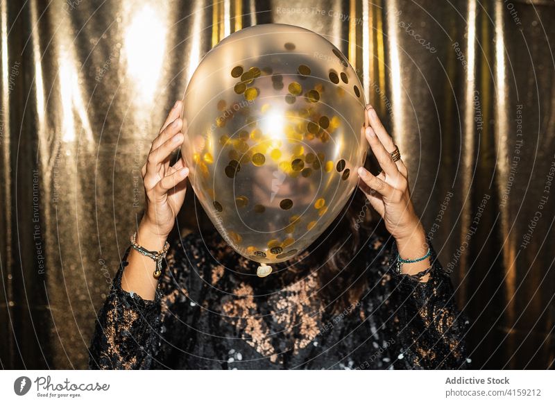 Woman with balloon at party golden woman air balloon glamour festive dress cover face celebrate female black confetti decoration shiny bright fashion style