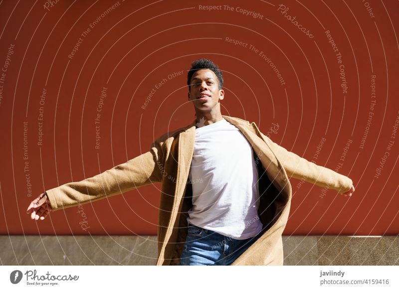 Young Cuban man dancing on red urban wall. black street happiness male cuban young expression person happy looking dancer outdoor one joy casual lifestyle adult