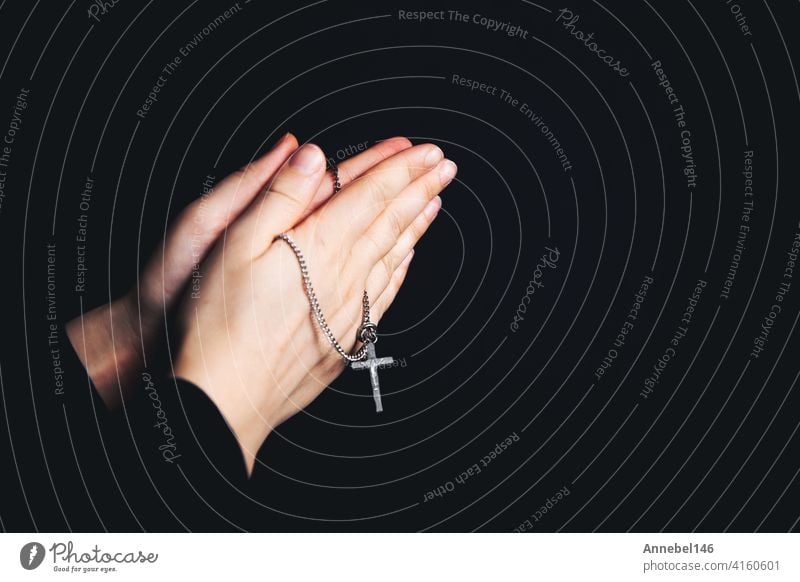 Praying hands holding a rosary, Closeup holding necklace with cross,pray for god in the dark, religious Christian symbol background woman icon believe love