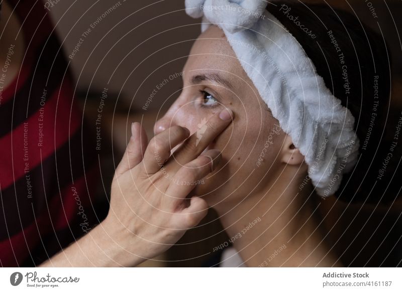 Makeup artist applying concealer on clients lower lid makeup visage cosmetic visagiste hand stylist professional salon occupation customer fingers women service