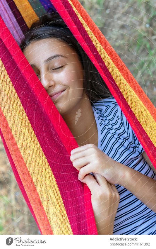 Woman having fun in hammock in park swing woman delight positive childish entertain summer weekend female lying green garden sunny relax rest playful young lady