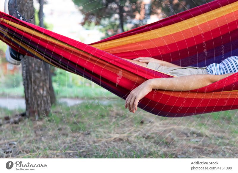 Woman having fun in hammock in park swing woman delight entertain summer weekend lying green garden sunny relax rest playful young lady joy cheerful tranquil