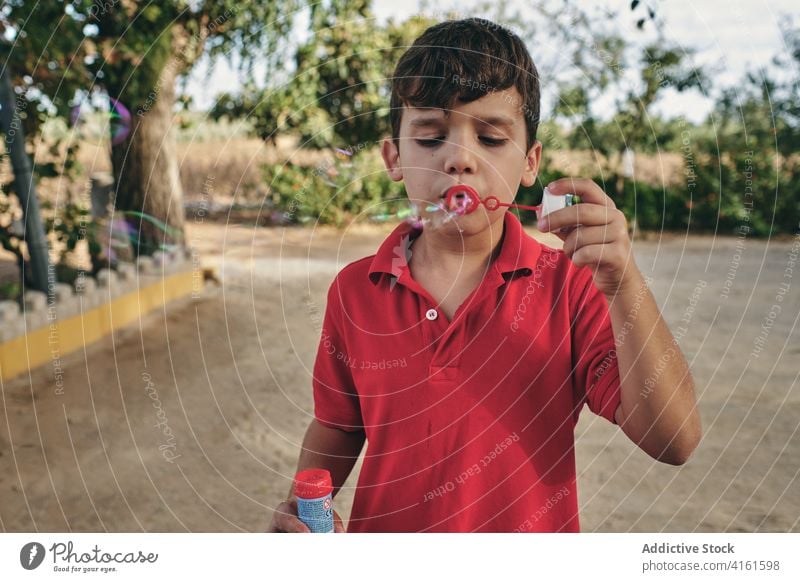 Boy blowing soap bubbles in summer child boy entertain having fun park outfit relax casual adorable holiday rest enjoy nature cute weekend kid carefree pleasure