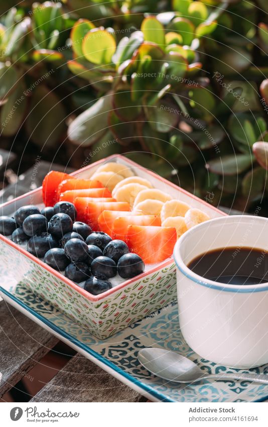 Tasty breakfast on wooden table in summer cafe bowl coffee morning sunlight nutrition super food healthy food cup aromatic drink dessert organic berry delicious