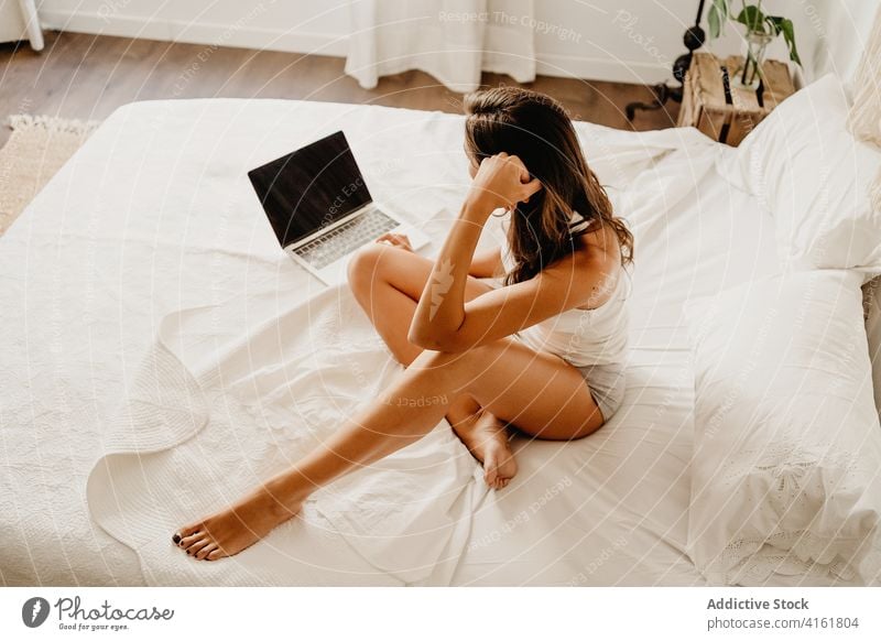 Woman using laptop in bed woman morning smile happy browsing bedroom home young female device gadget internet cozy online delight awake communicate social media