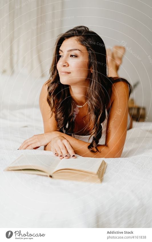 Woman reading book in bedroom woman home morning relax rest comfort chill cozy positive inspiration lean young female smile literature hobby pleasure leisure