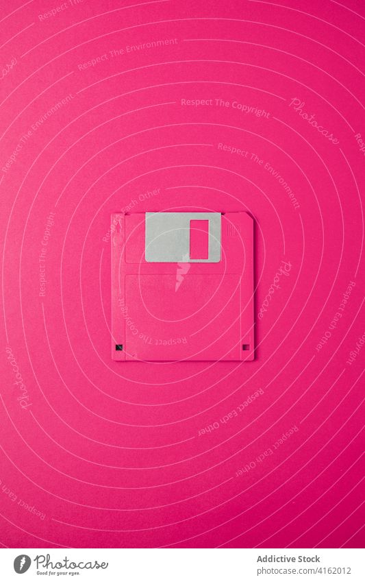 Computer floppy disk on pink background old diskette computer pc old fashioned information data obsolete equipment device tool vintage retro accessory minimal