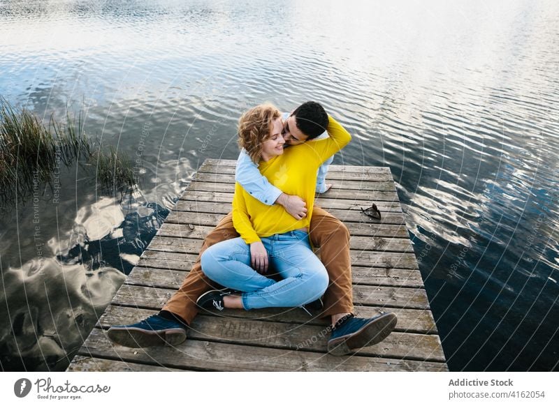 Content couple hugging on pier in summer wooden lake embrace love tender relationship pond carefree calm girlfriend boyfriend gentle romantic affection relax