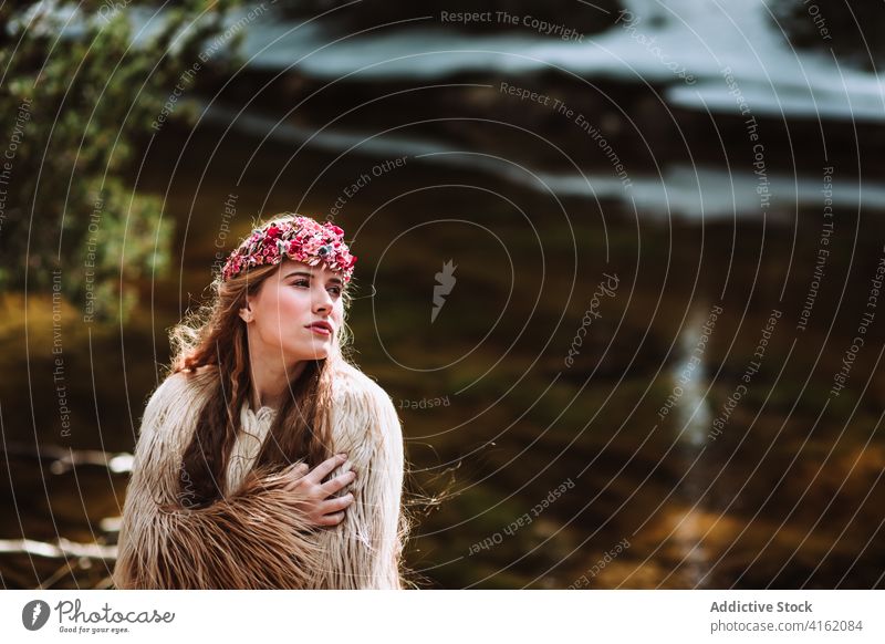 Young woman in boho outfit walking near river in spring forest nordic tradition fashion style fur scandinavian charming bridal young female dress nature woods