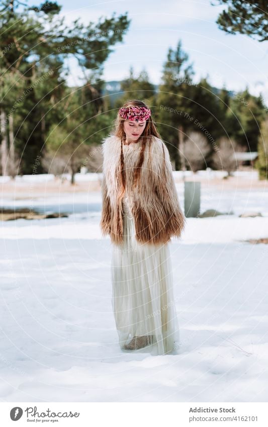Nordic bride in fur wear standing on snowy meadow woman fashion nordic wedding style nature forest wreath season blond winter spring young female jacket floral
