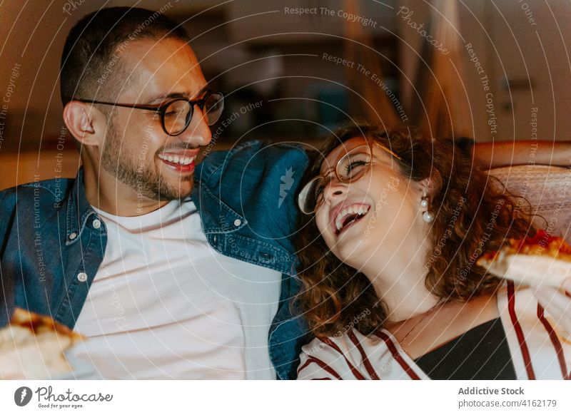 Cheerful friends resting and laughing friendship toothy smile fun relax enjoy content carefree glad man woman curly hair eyeglasses accessory lounge chill