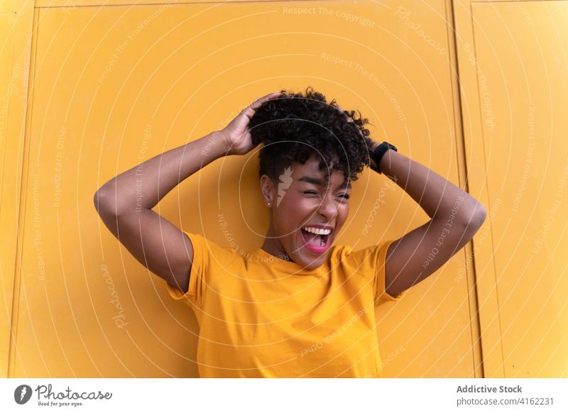 Cheerful black woman in bright outfit happy cheerful colorful smile yellow style positive confident young african american ethnic afro casual modern curly hair