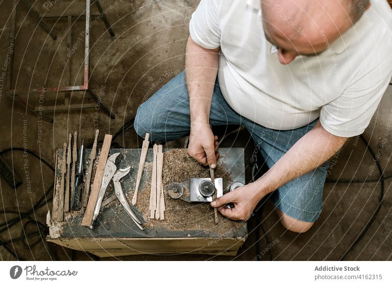 Unrecognizable male woodworker working in garage grind carpentry workshop man carpenter fold fan handmade wooden occupation skill tool messy artisan craft