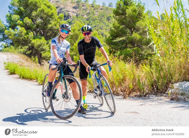 Couple of cyclists looking at camera bike ride mountain happy bicycle active smiling nature sport couple lifestyle activity summer adventure route navigator