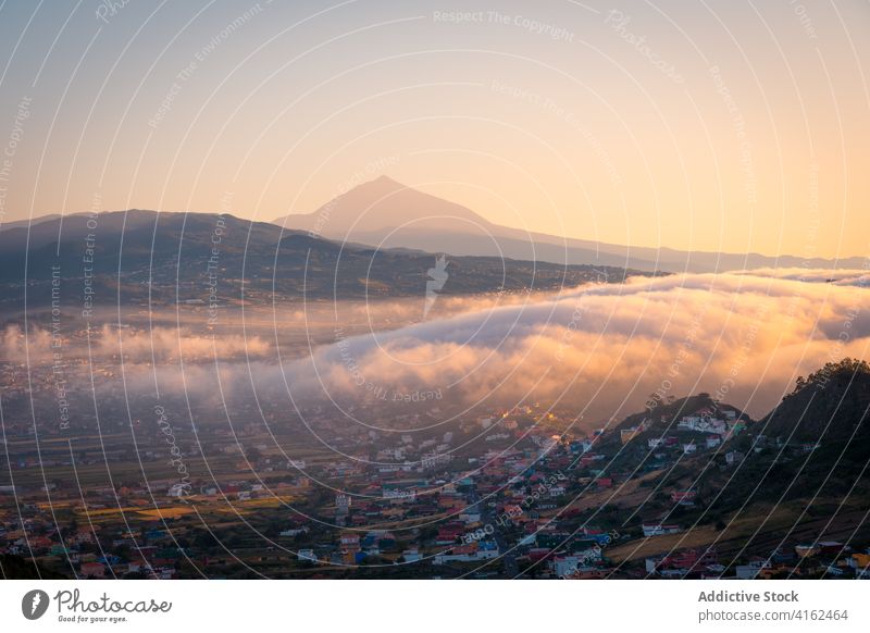 Amazing view of settlement in mountains in morning spectacular city fog highland valley mist thick sunrise canary islands spain tenerife cloud picturesque
