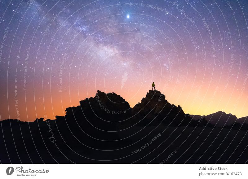 Traveling man on hill at night sky starry traveler together silhouette galaxy milky way admire canary islands tenerife spain rock dark atmosphere astronomy