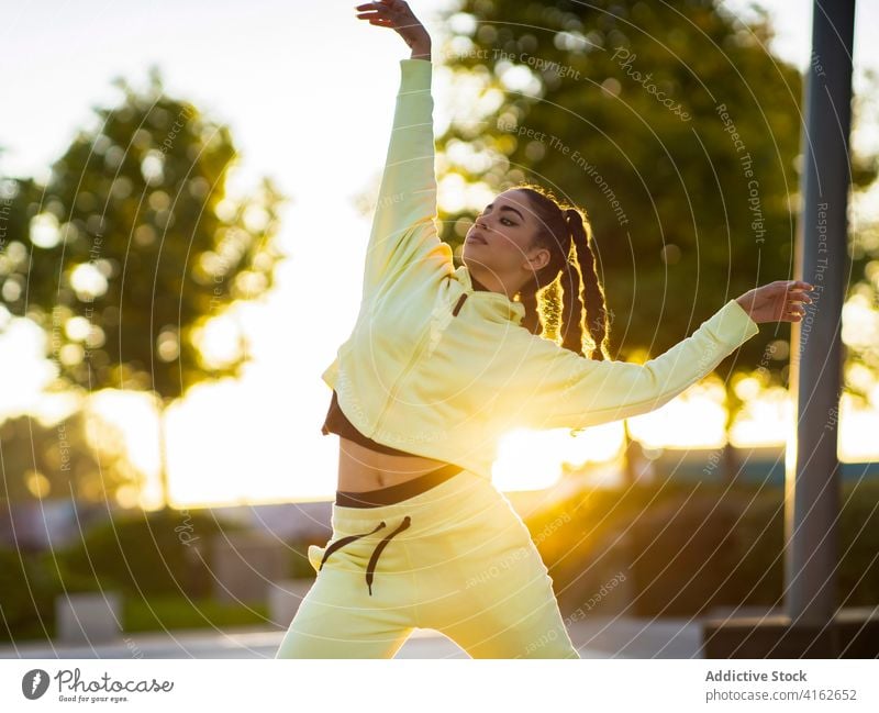 Active young ethnic lady dancing in park at sundown woman dance perform active movement trendy grace gorgeous energy modern sunset ballerina sunlight female