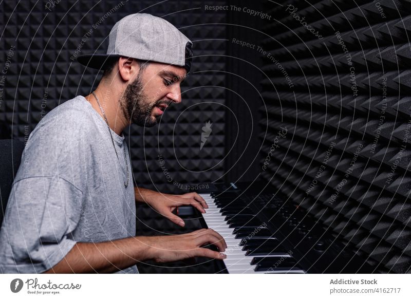Man playing synthesizer in recording studio man sound proof foam male acoustic room equipment music professional hobby talent device art artist guy musician