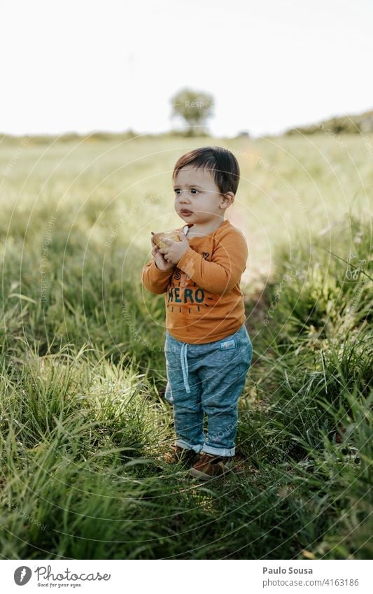 Child eating fruit Boy (child) 1 - 3 years Caucasian Eating Fruit Field Spring Day Colour photo Infancy Toddler Human being Exterior shot Playing Life