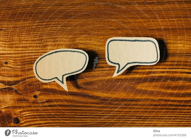 Two empty speech bubbles on wood. Communication, talk and conversation. communication two Speech bubbles Empty Dialogue To talk Communicate argue Wood