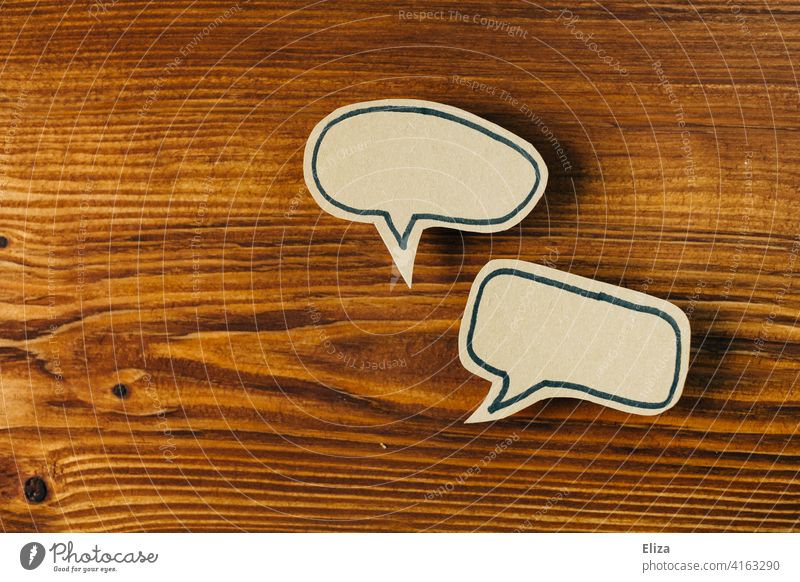 Two empty speech bubbles on wood. Communication, talk and conversation. communication two Speech bubbles Empty Dialogue To talk Communicate argue Wood