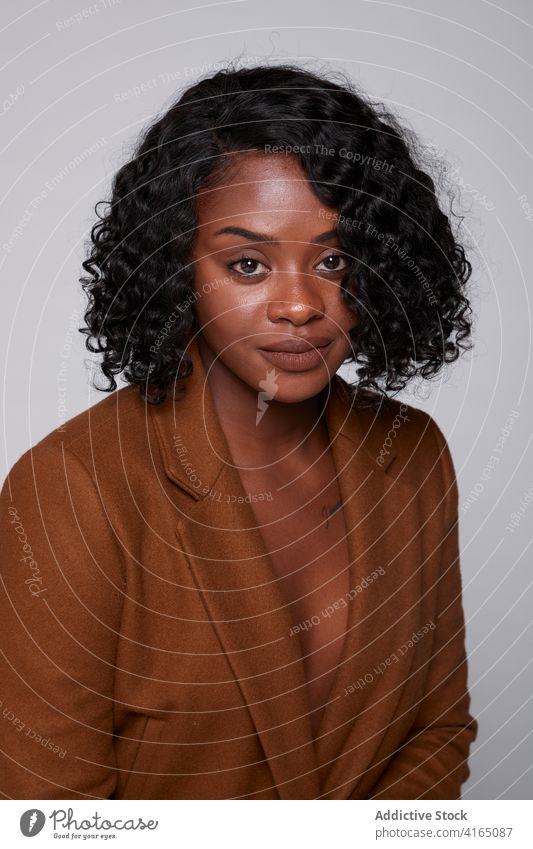 Charming black woman in studio jacket casual confident model style complexion charming appearance female ethnic african american fashion trendy calm curly hair