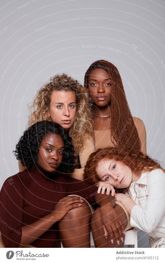 Multiethnic women gathering on gray background unity hug together friendship cuddle tender company multiethnic multiracial diverse black african american