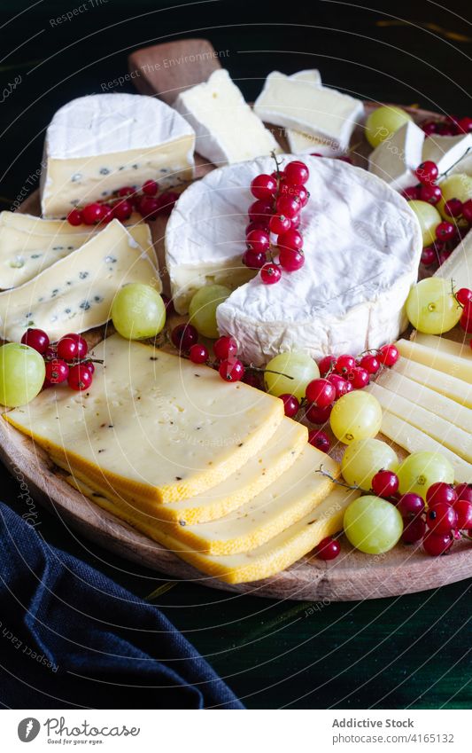 Delicious cheese platter with grapes and currants assorted parmesan mozzarella slice camembert tasty delicious various dish appetizing chef serve piece organic