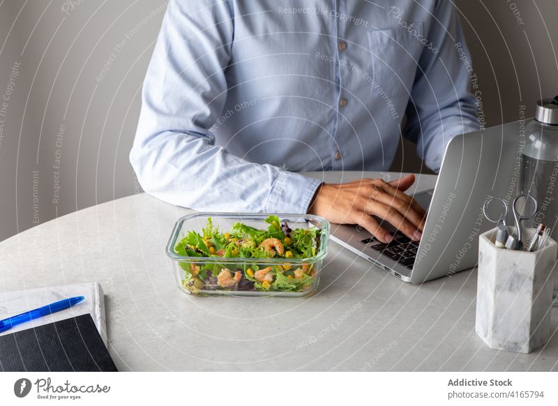 Crop worker having lunch in office eat workplace food salad nutrition healthy food employee table delicious lunch box tasty dish greenery snack sit desk meal