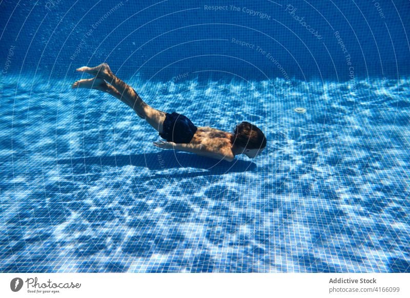 Teenage boy diving into pool water teenage energy dive swim active underwater activity carefree playful splash aqua resort plunge enjoy relax delight bubble